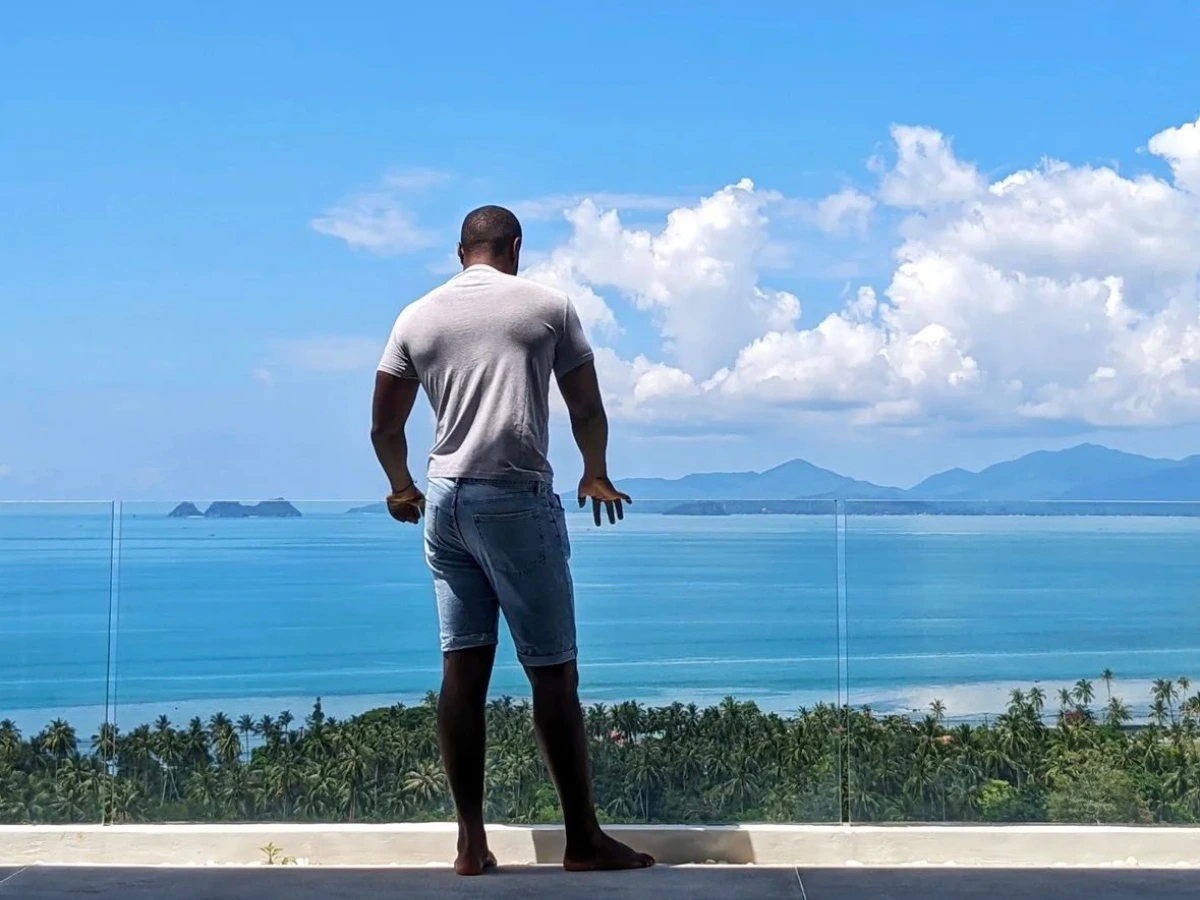Alpha contemplant l'océan depuis sa villa à Koh Samui
